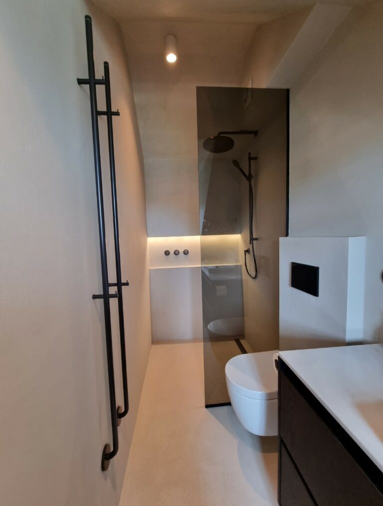 Badkamer renovatie uitgevoerd in betoncire met design radiator en hotbath kranen